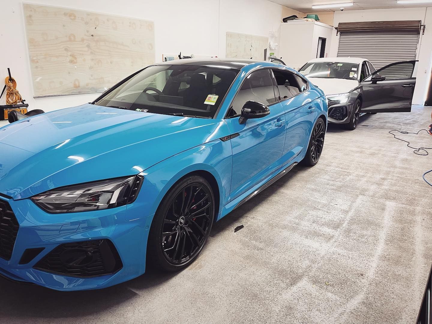 A Blue Car is Parked in a Garage Next to a White Car — Diamond Tints In Bungendore, ACT