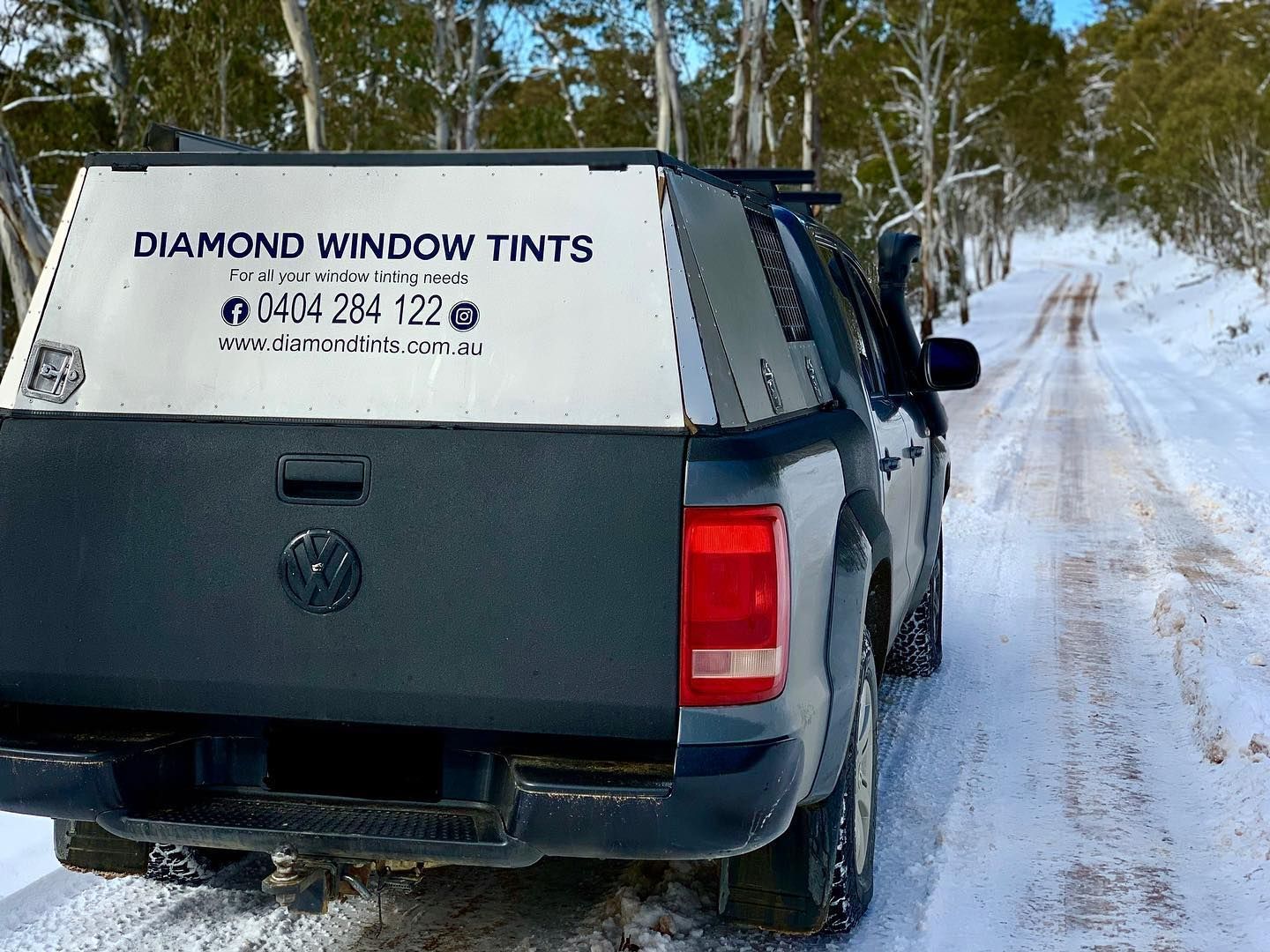 A Diamond Window Tints Truck is Driving Down a Snowy Road — Diamond Tints In Yass, ACT