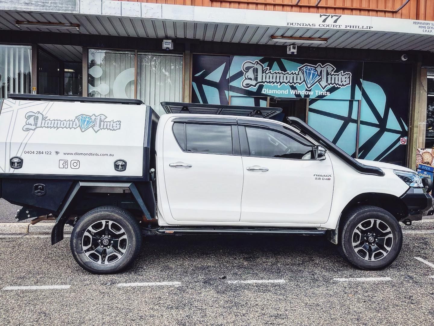 A White Truck With a Canopy is Parked in Front of a Building — Diamond Tints In Phillip, ACT