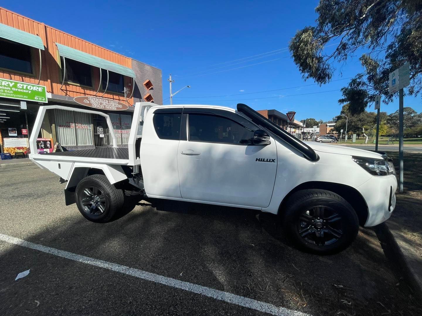 A White Truck is Parked in a Parking Lot in Front of a Building — Diamond Tints In Phillip, ACT