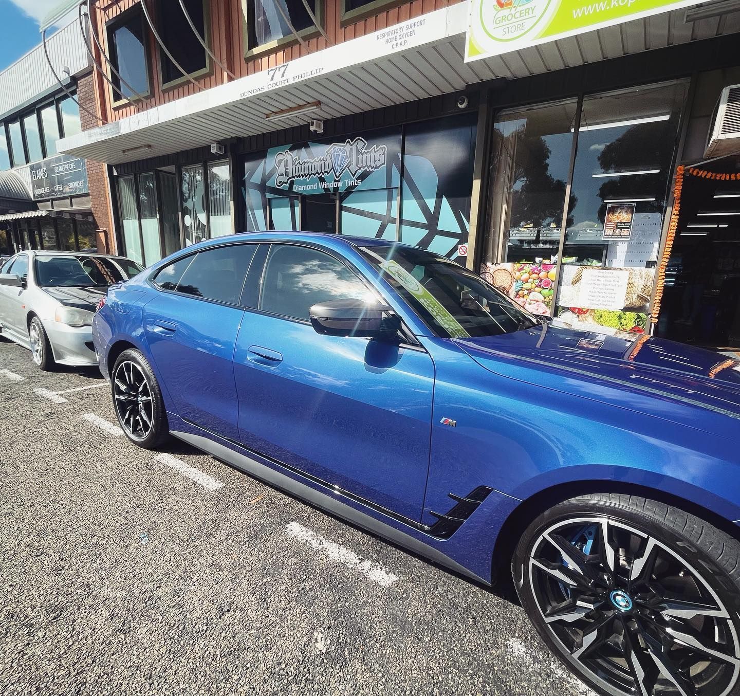 A Blue Car is Parked in Front of a Building — Diamond Tints In Phillip, ACT