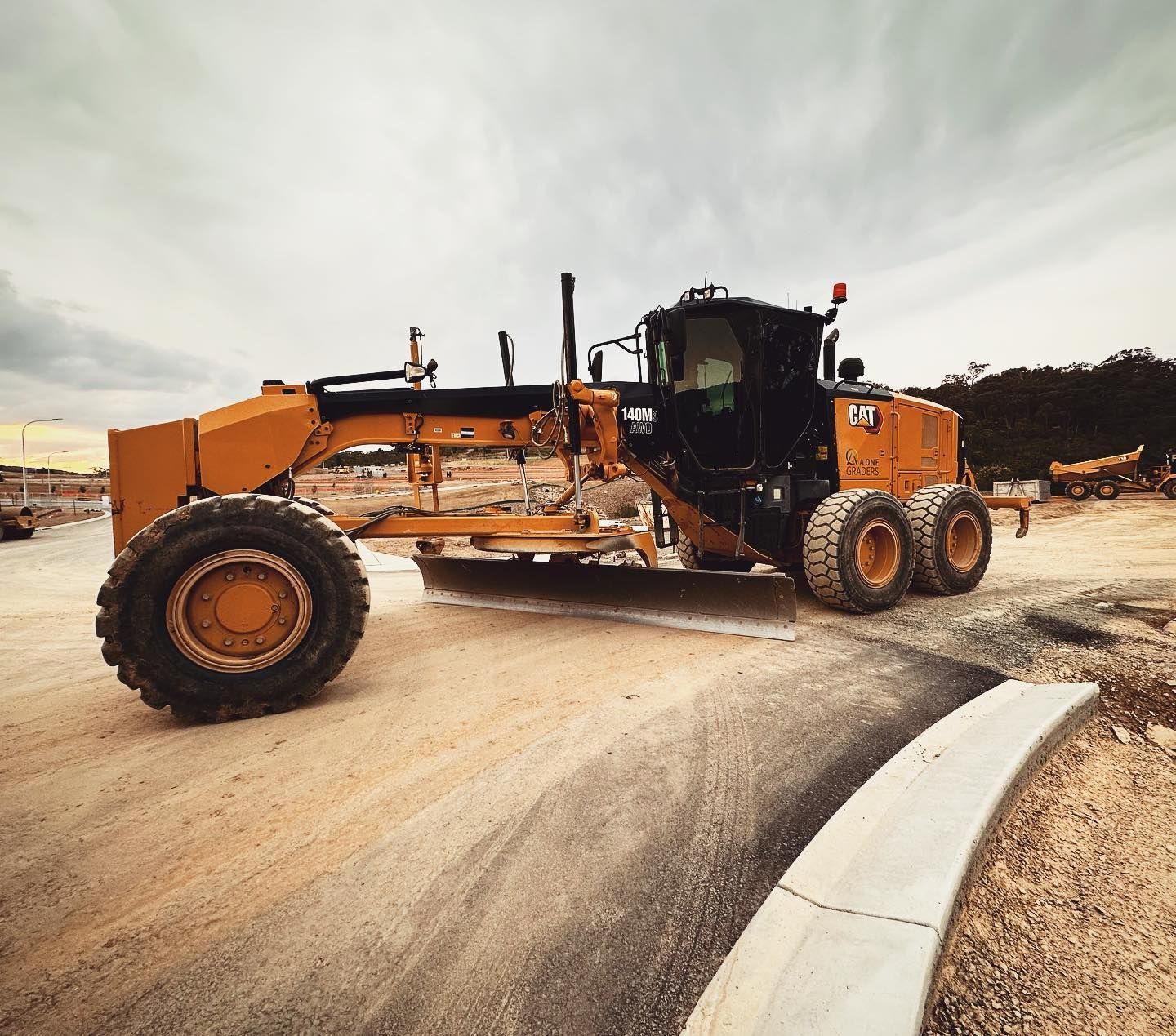 A Large Yellow Tractor is Driving Down a Dirt Road — Diamond Tints In Phillip, ACT