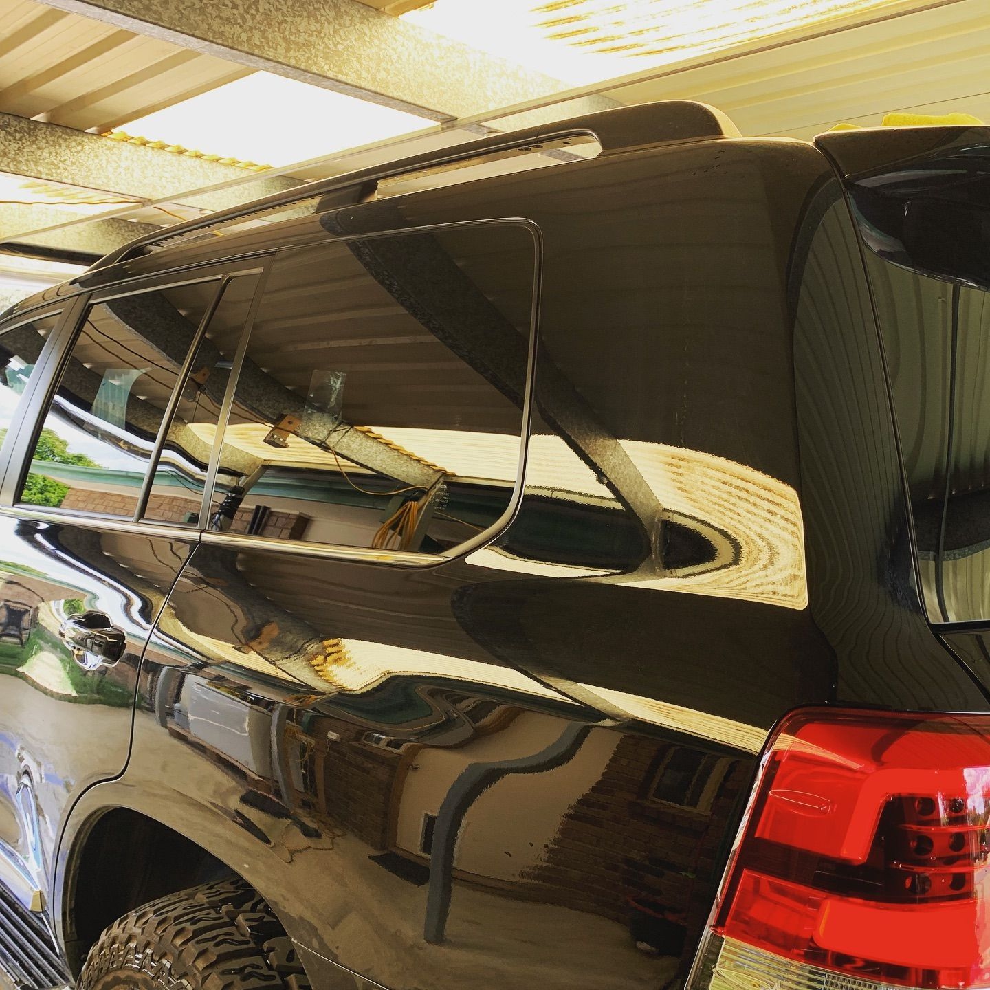 A Black SUV With a Red Tail Light is Parked in a Garage — Diamond Tints In Queanbeyan, ACT
