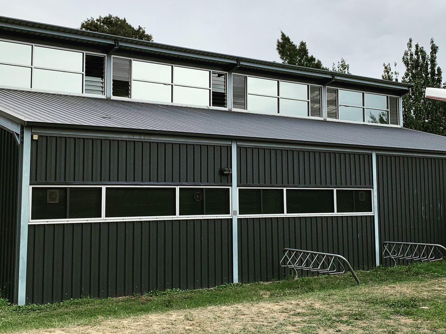 A Large Building With a Lot of Windows is Sitting on Top of a Lush Green Field — Diamond Tints In Queanbeyan, ACT