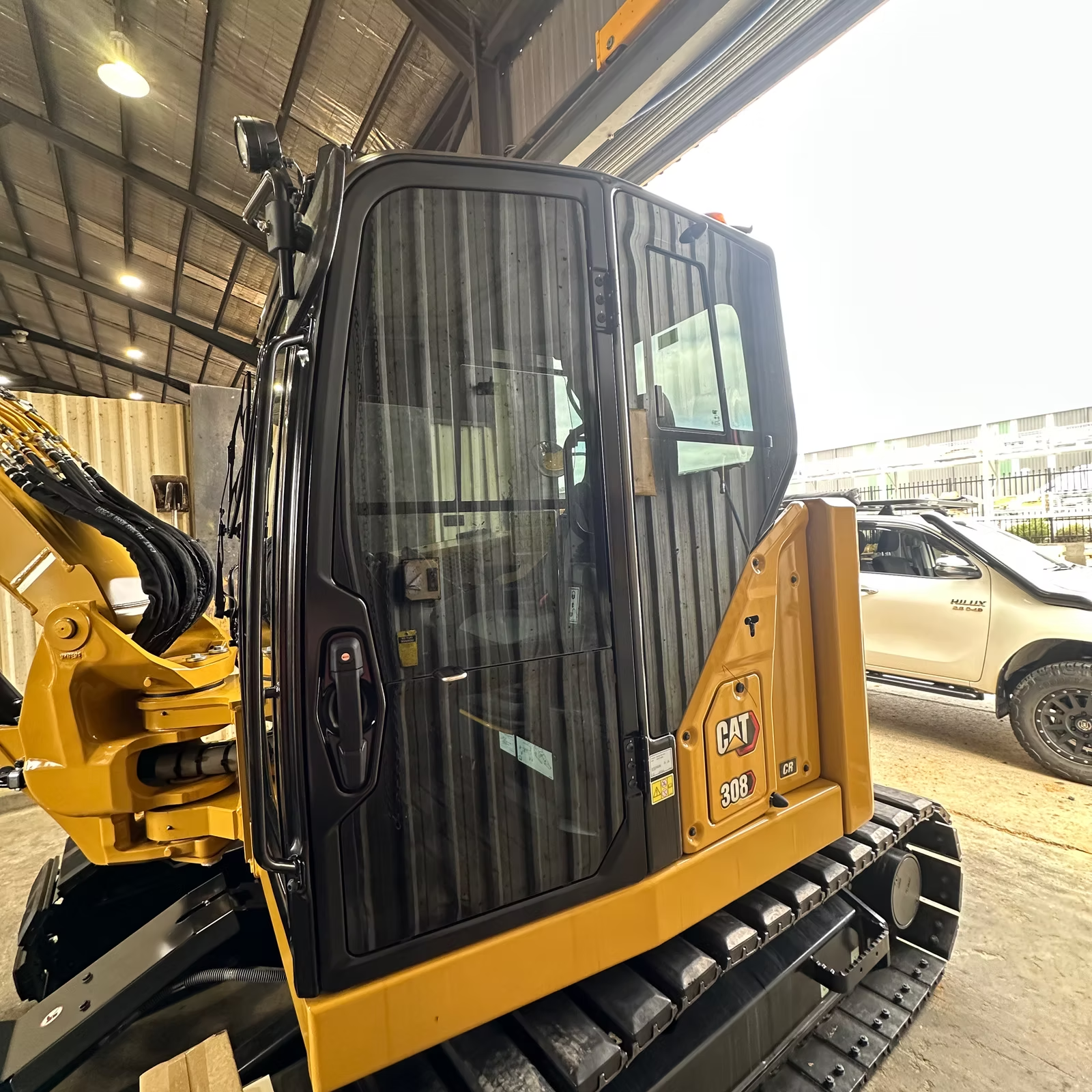A Yellow Bulldozer is Parked in a Garage Next to a White Truck — Diamond Tints In Phillip, ACT