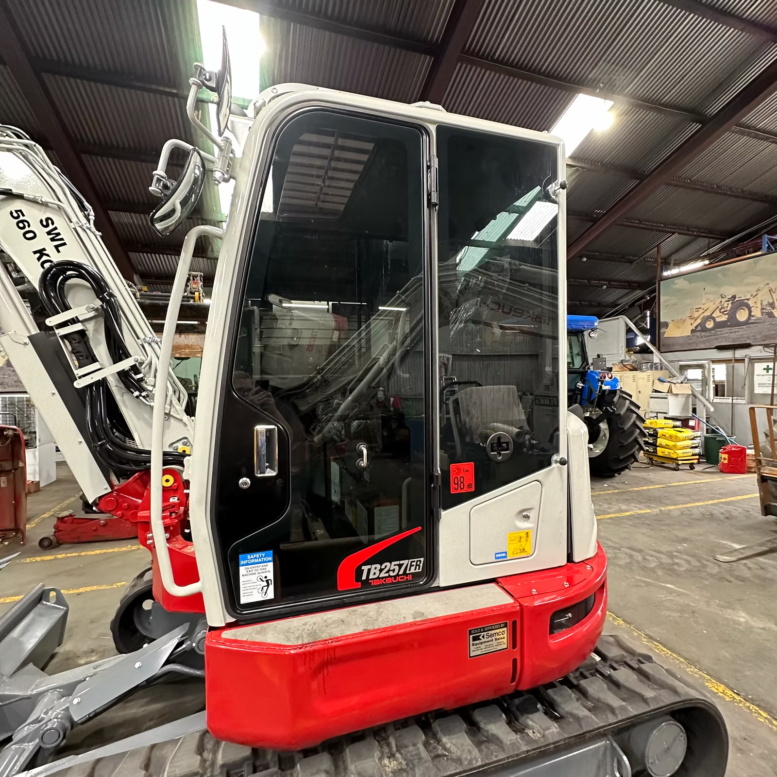 A red and white tractor is parked in a garage — Diamond Tints In Woden, ACT
