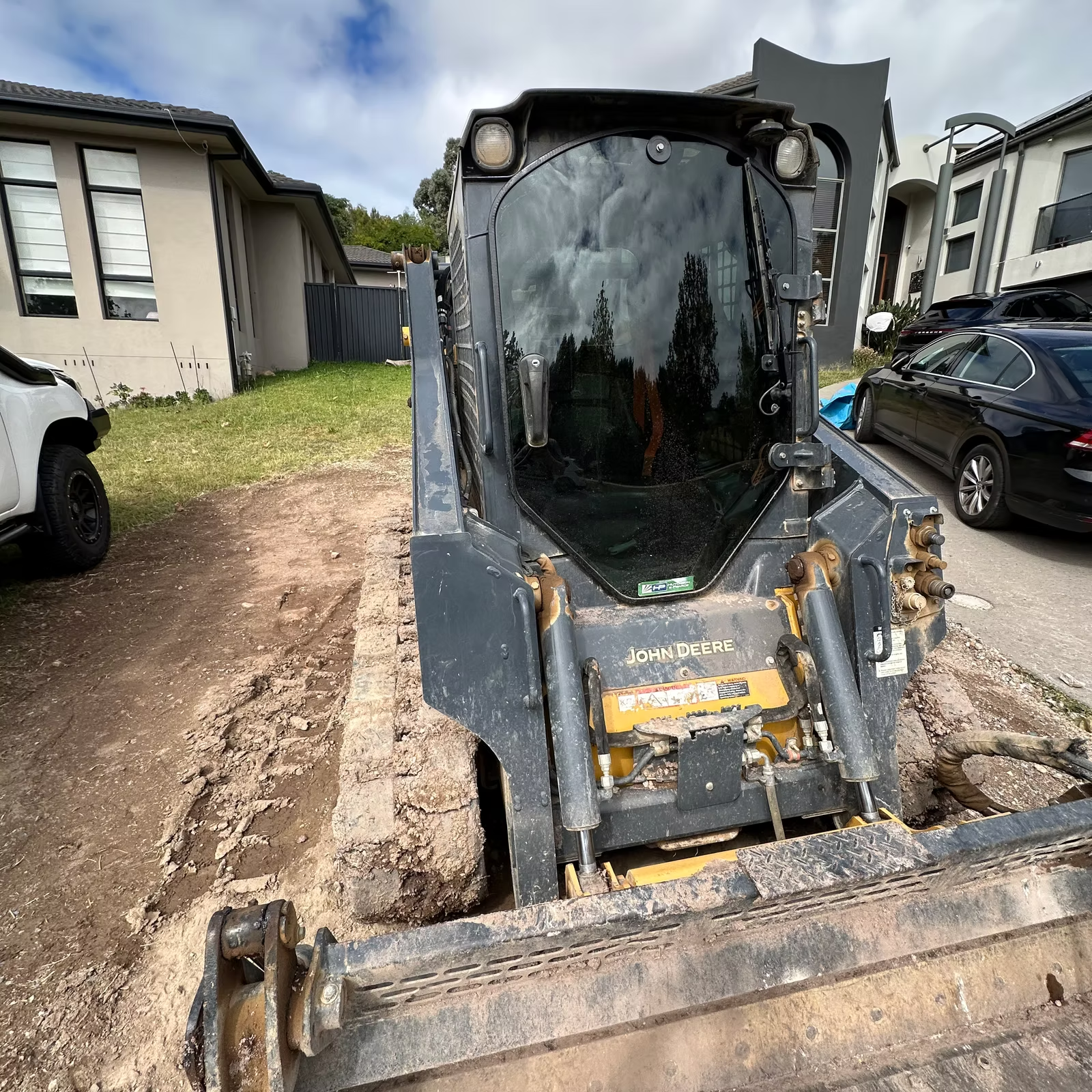A Yellow and White Excavator is Working on a Construction Site — Diamond Tints In Queanbeyan, ACT