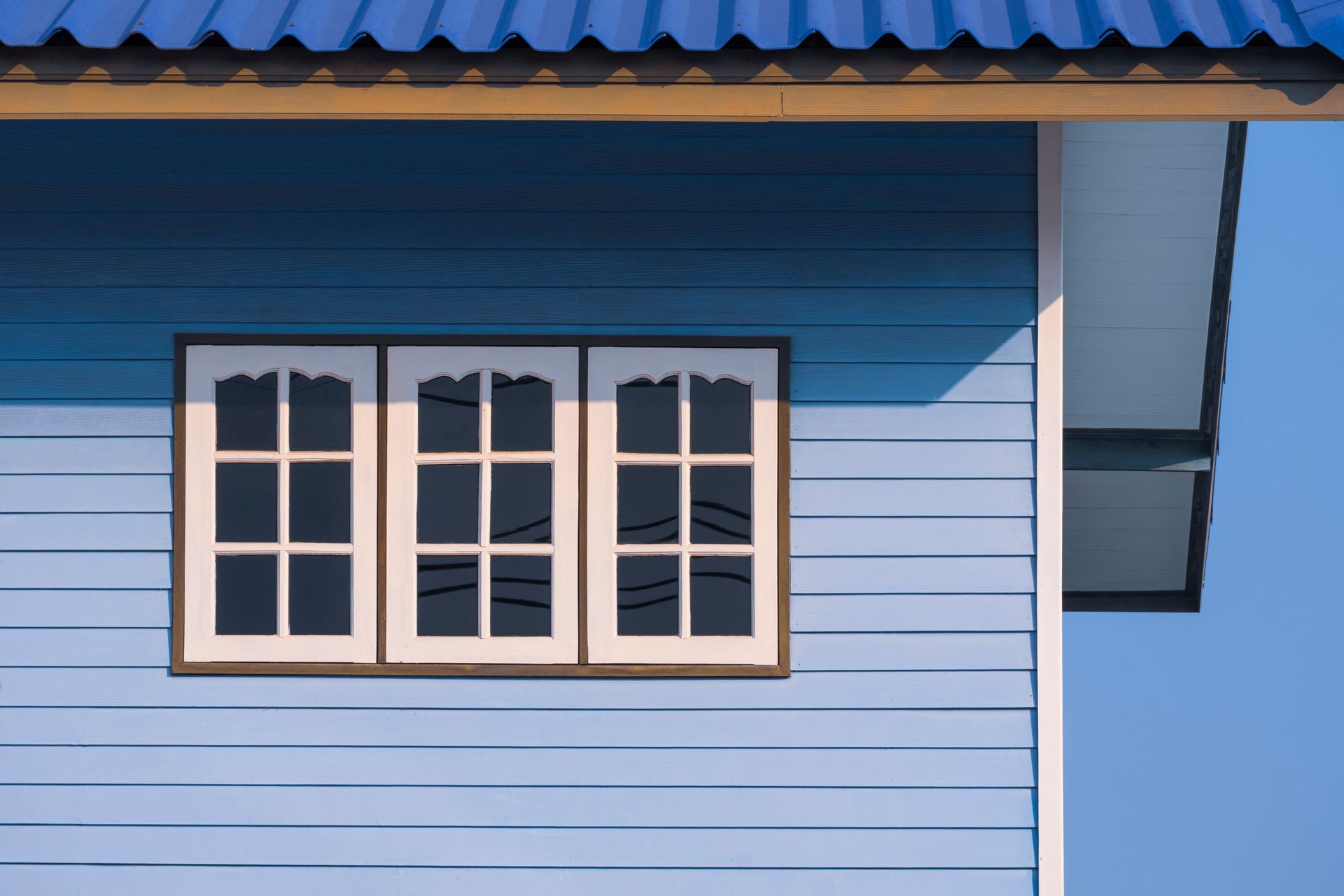 A Blue House With Three Windows and a Blue Roof — Diamond Tints In Queanbeyan, ACT