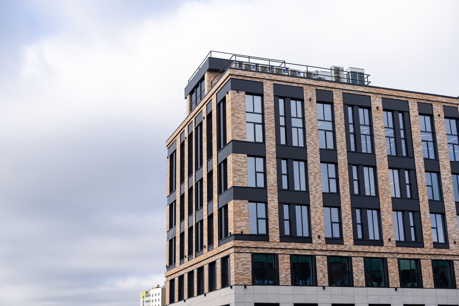 A Large Brick Building With a Lot of Windows Against a Cloudy Sky — Diamond Tints In Woden, ACT