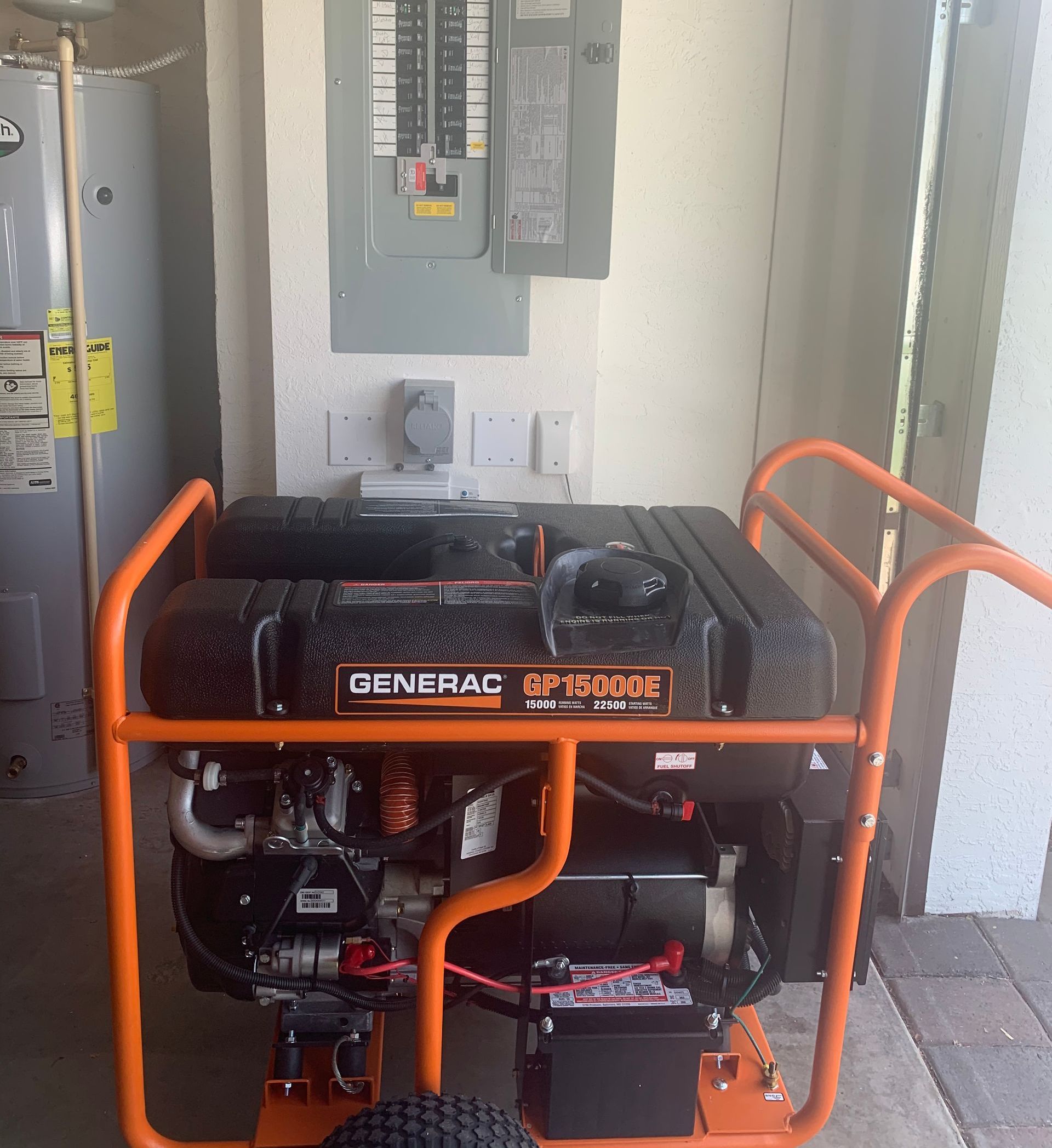 An orange portable generator is sitting on a brick sidewalk.