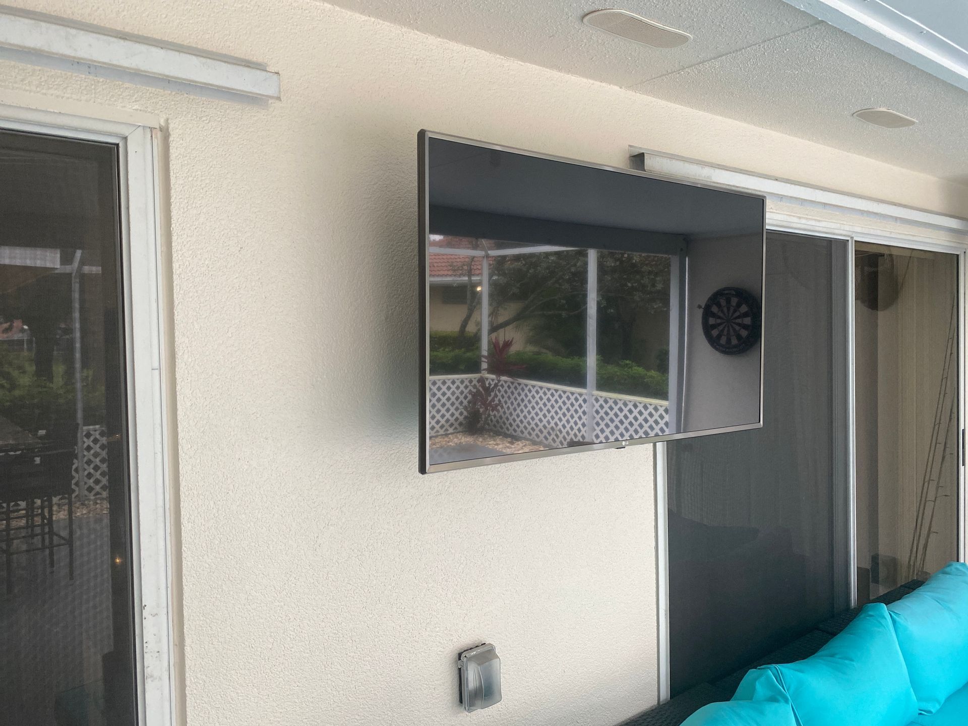 A flat screen tv is mounted on a wall next to a couch.