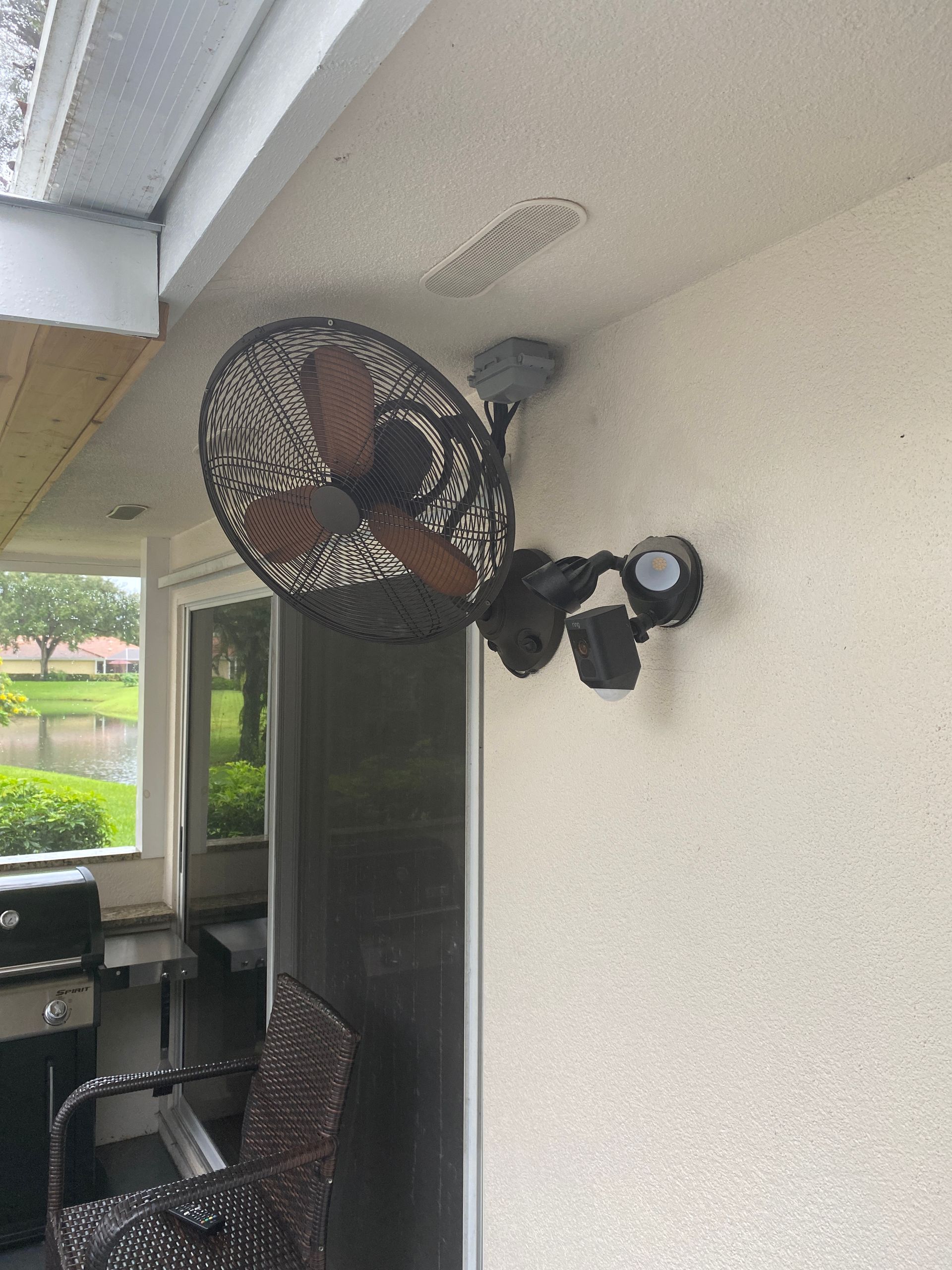 A fan is mounted to the side of a building.