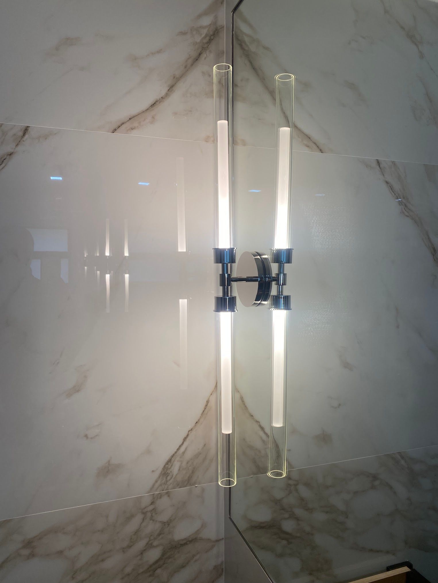 A light fixture is hanging on a marble wall.