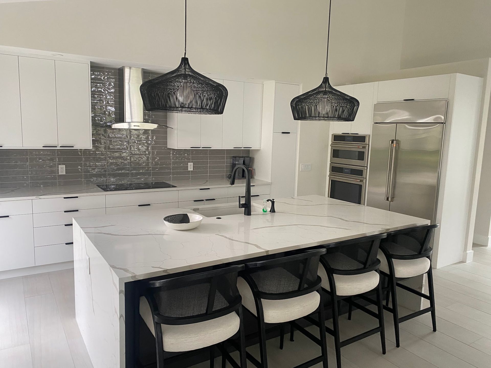 A kitchen with white cabinets and a large island