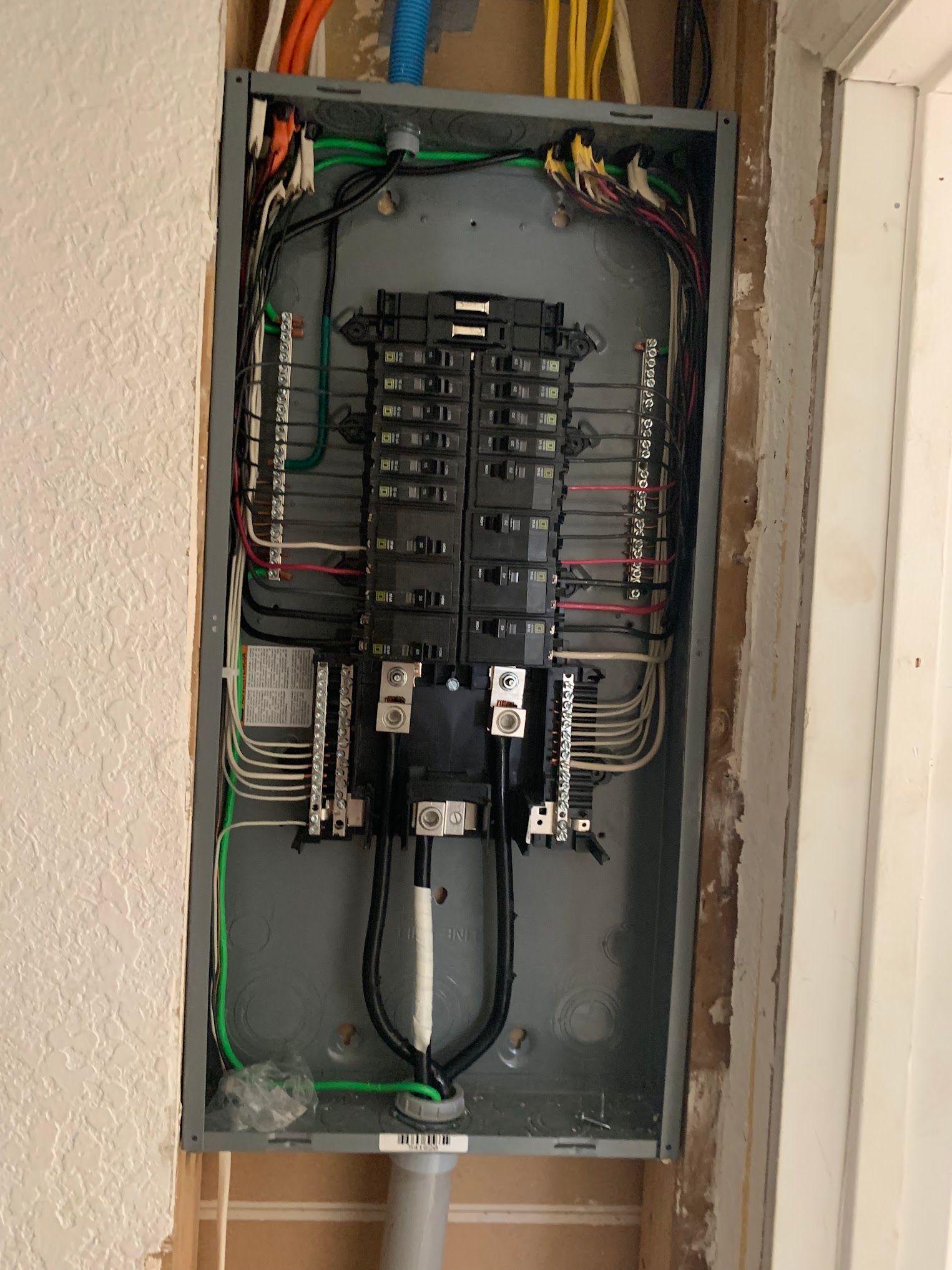 A electrical panel is hanging on a wall next to a door.