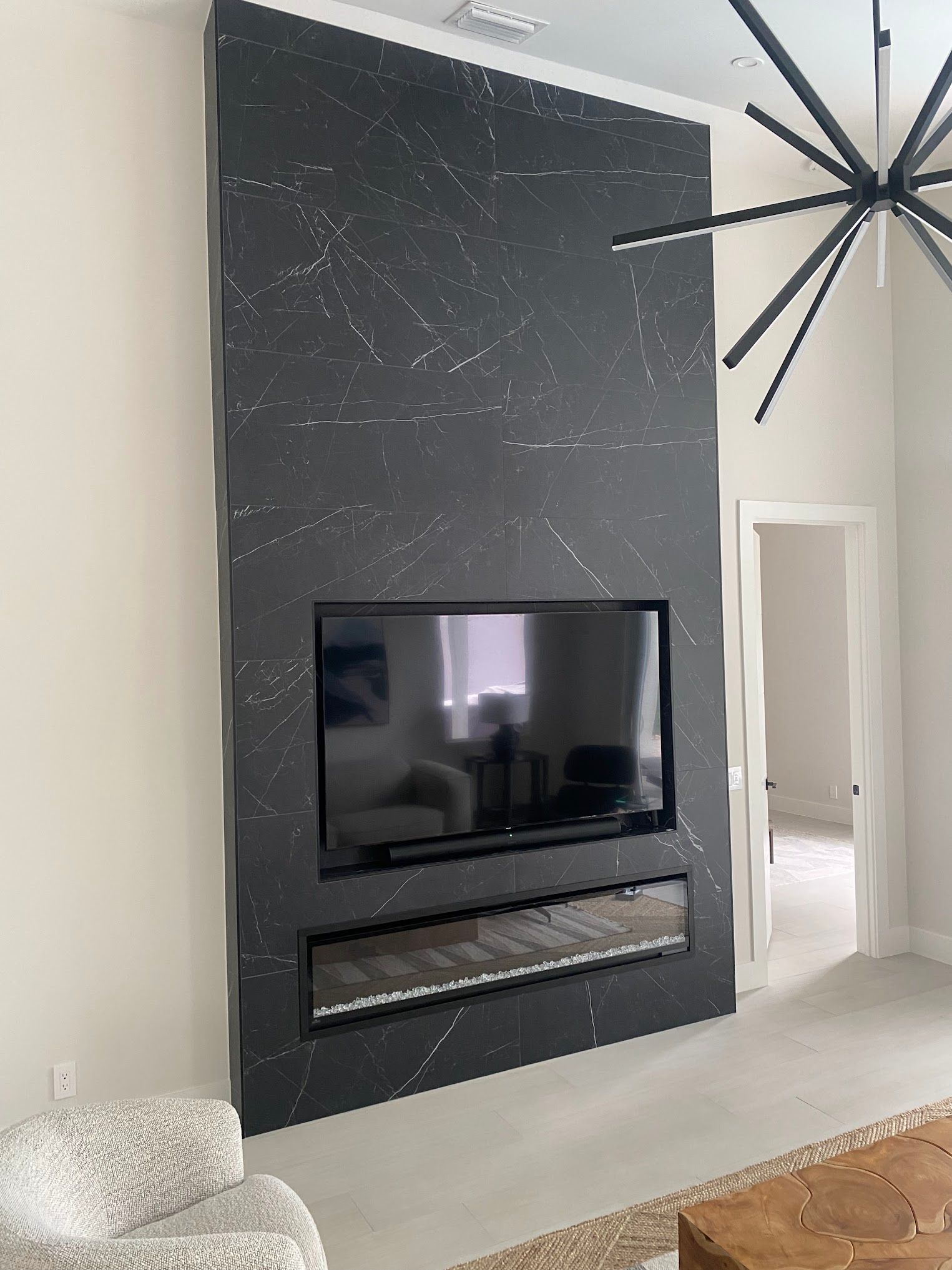 A living room with a fireplace and a flat screen tv on the wall.