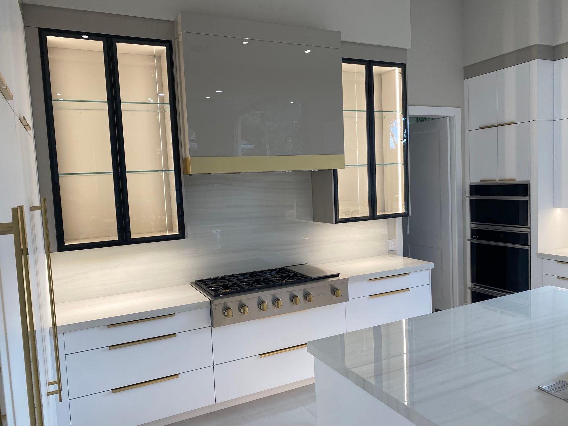 A kitchen with white cabinets and a stove top oven.