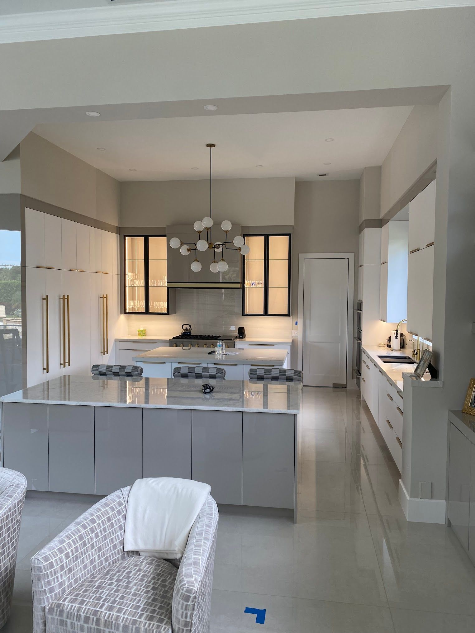 A kitchen with white cabinets and a large island in the middle