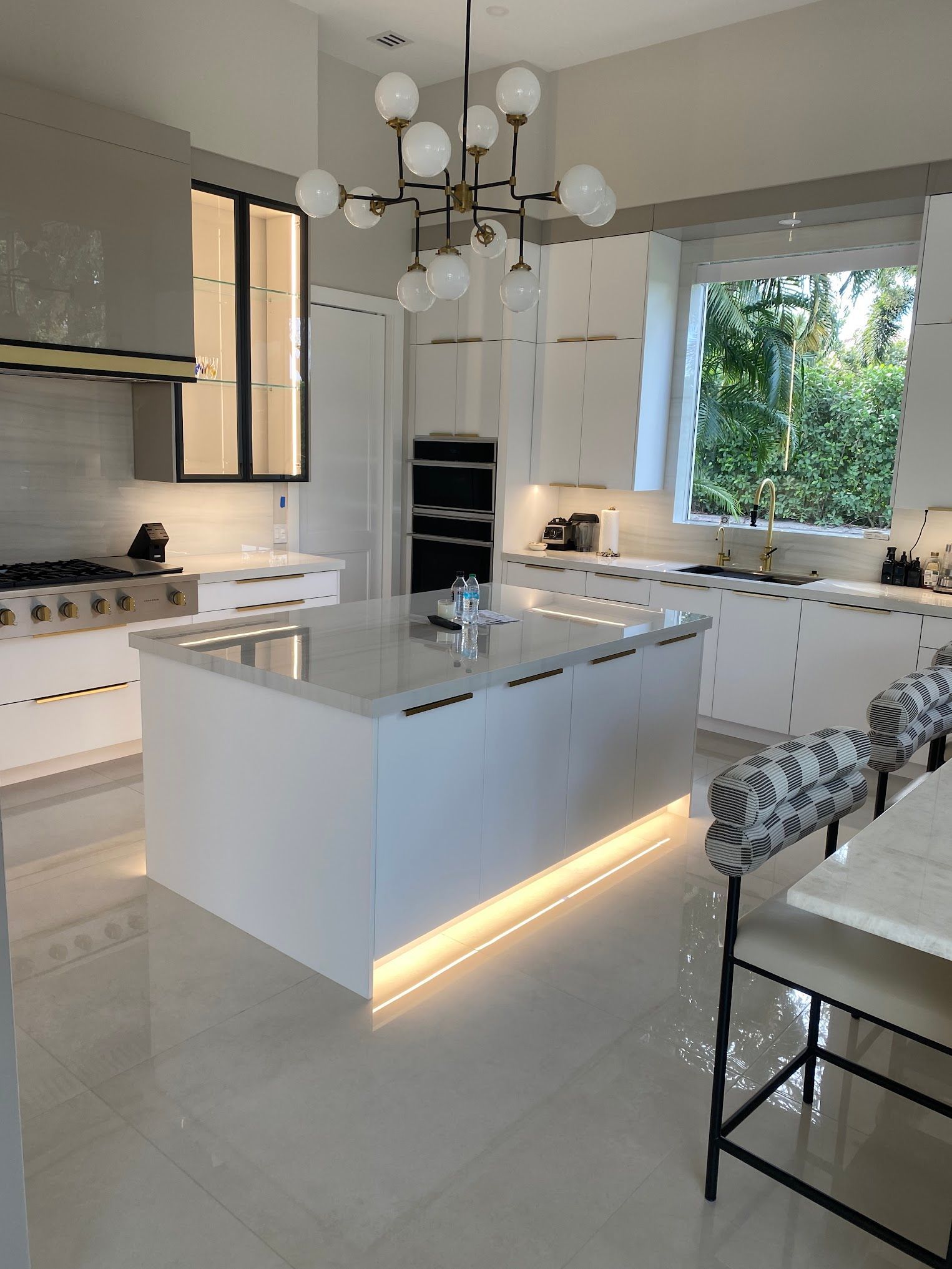 A kitchen with white cabinets and a large island