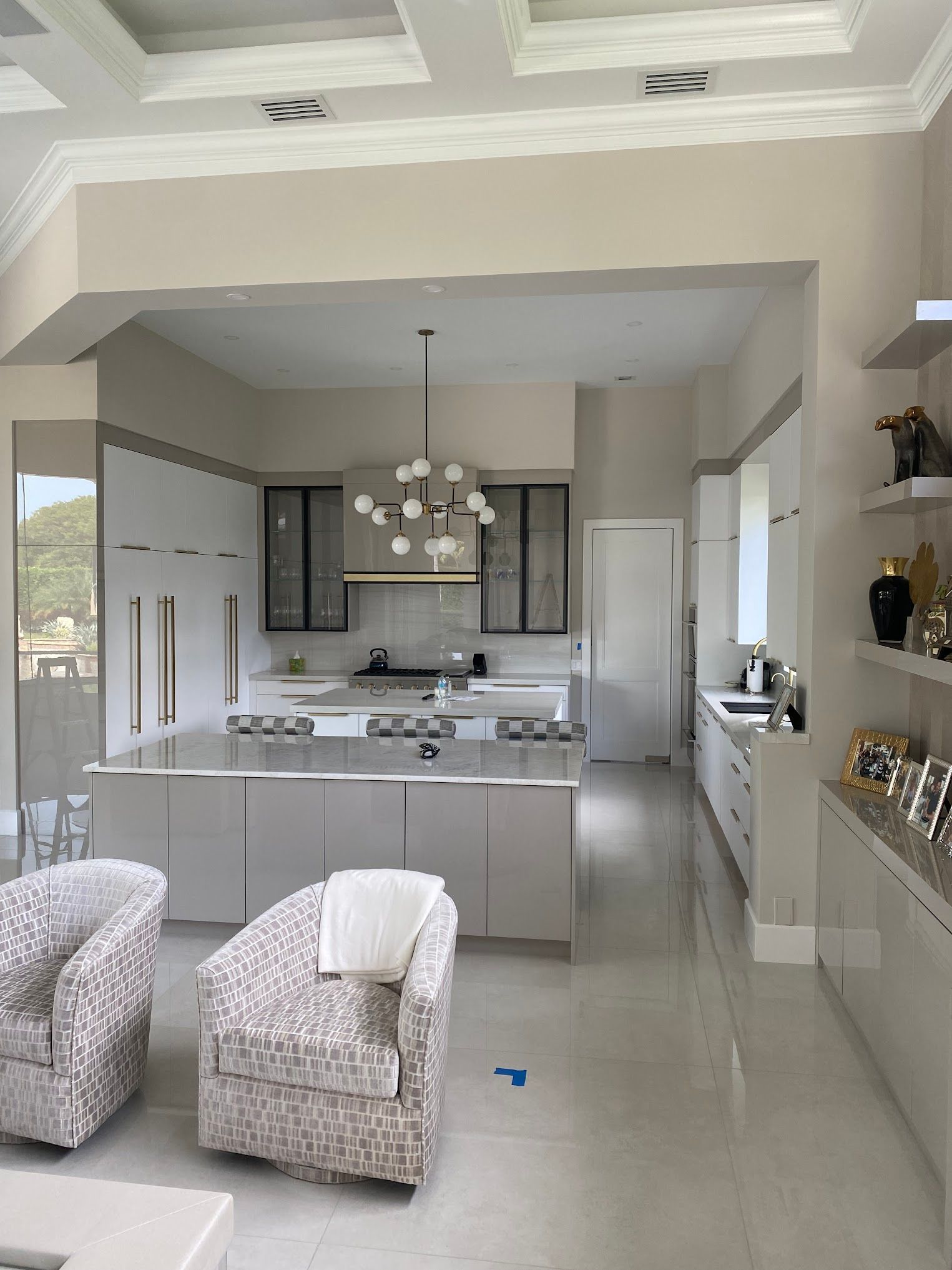 A kitchen with white cabinets and a large island in the middle