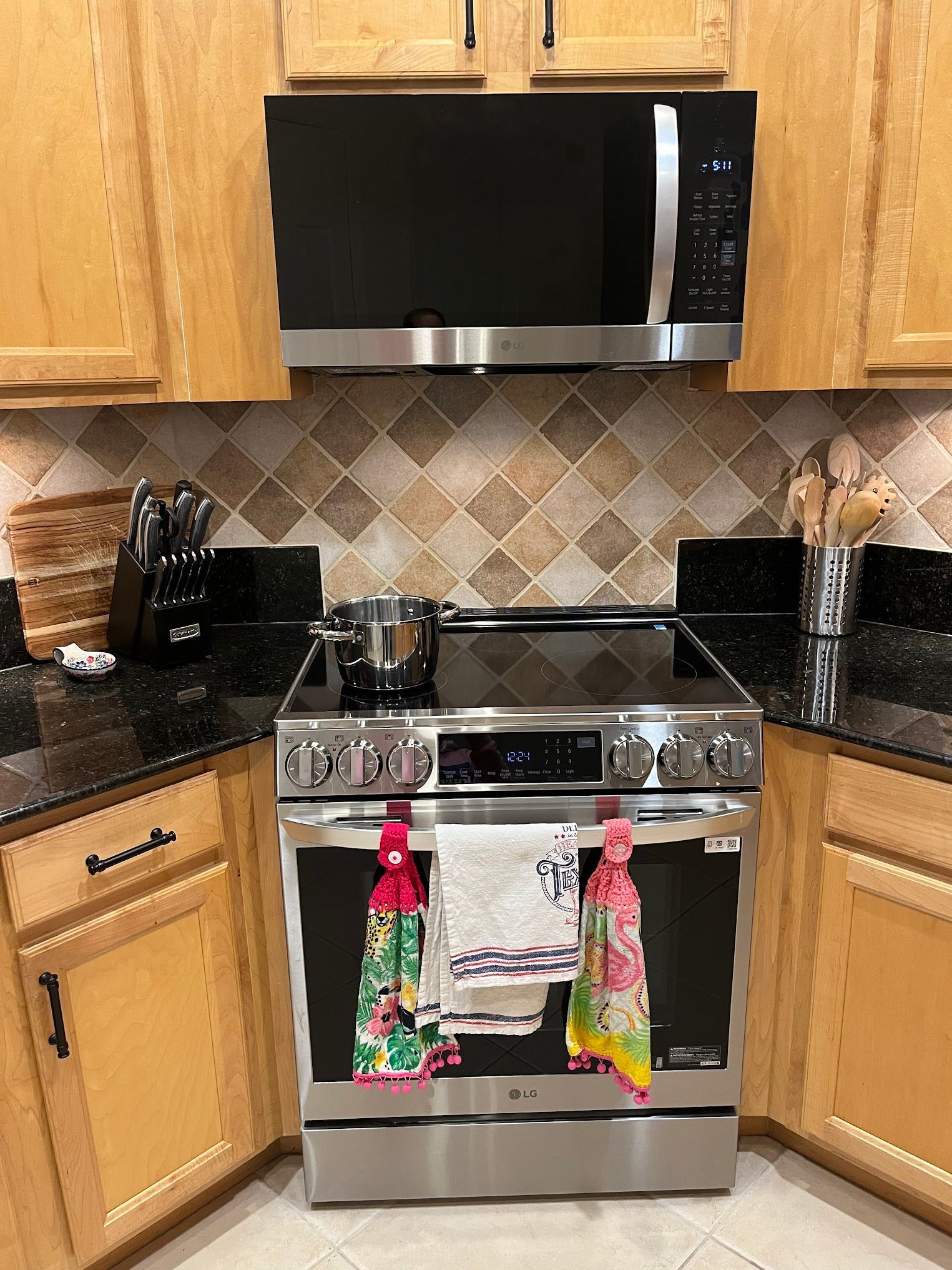 A kitchen with a stove , microwave , and cabinets.