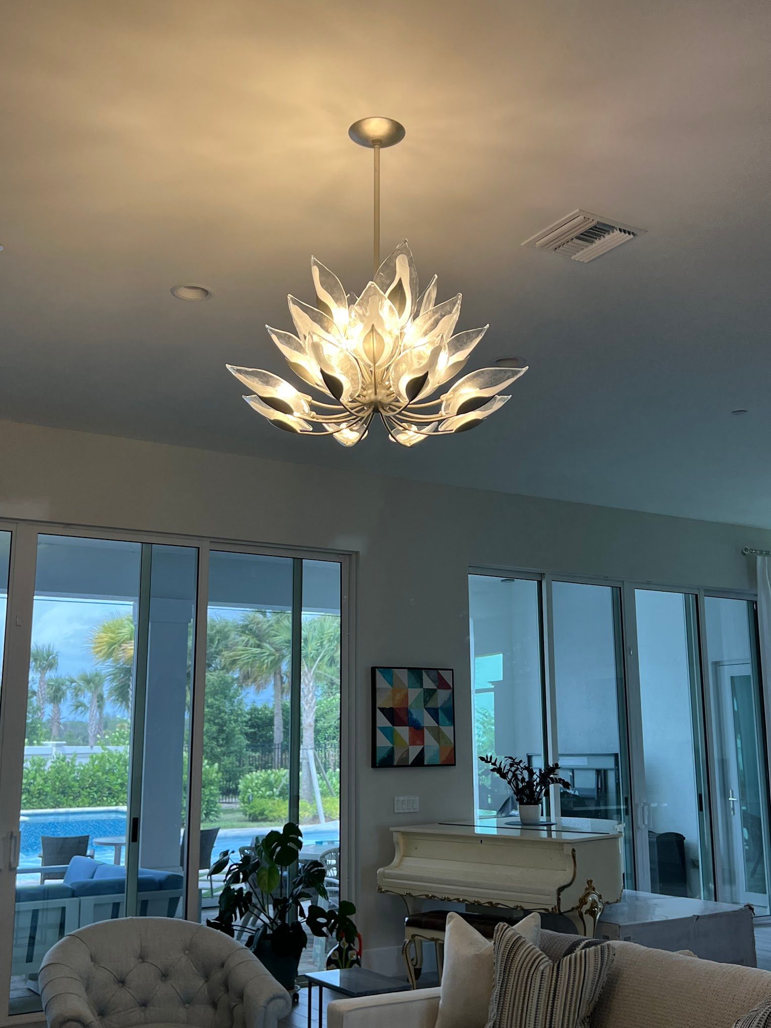 A living room with a chandelier hanging from the ceiling.