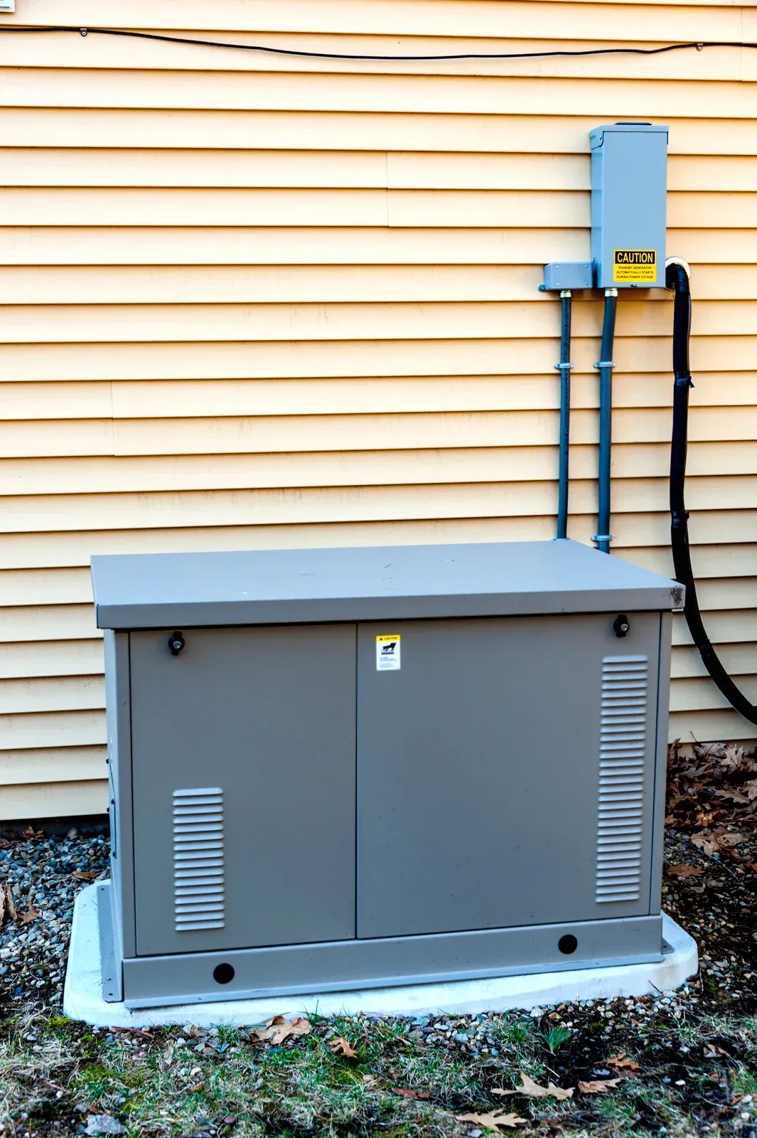 A generator is attached to the side of a house.