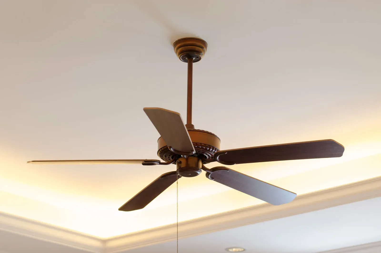 A ceiling fan is hanging from the ceiling in a room
