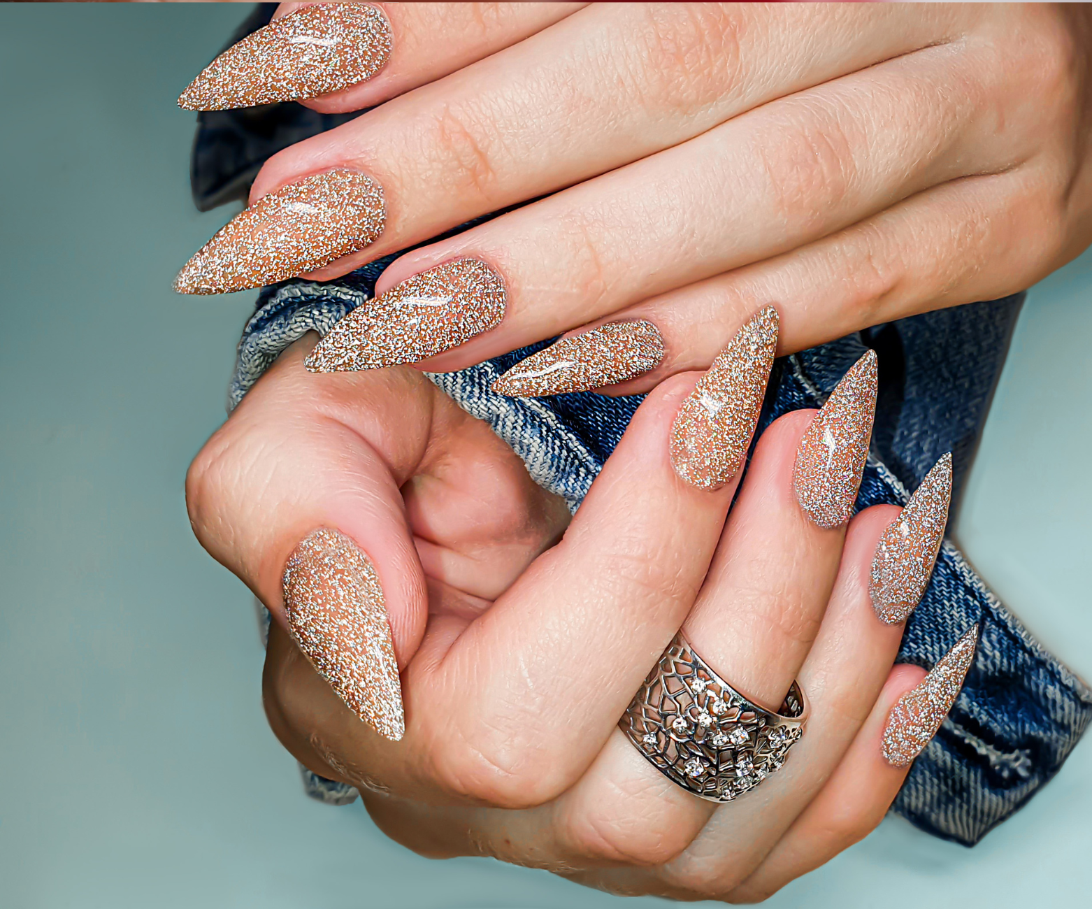 a woman 's hands with long nails and a ring on her finger