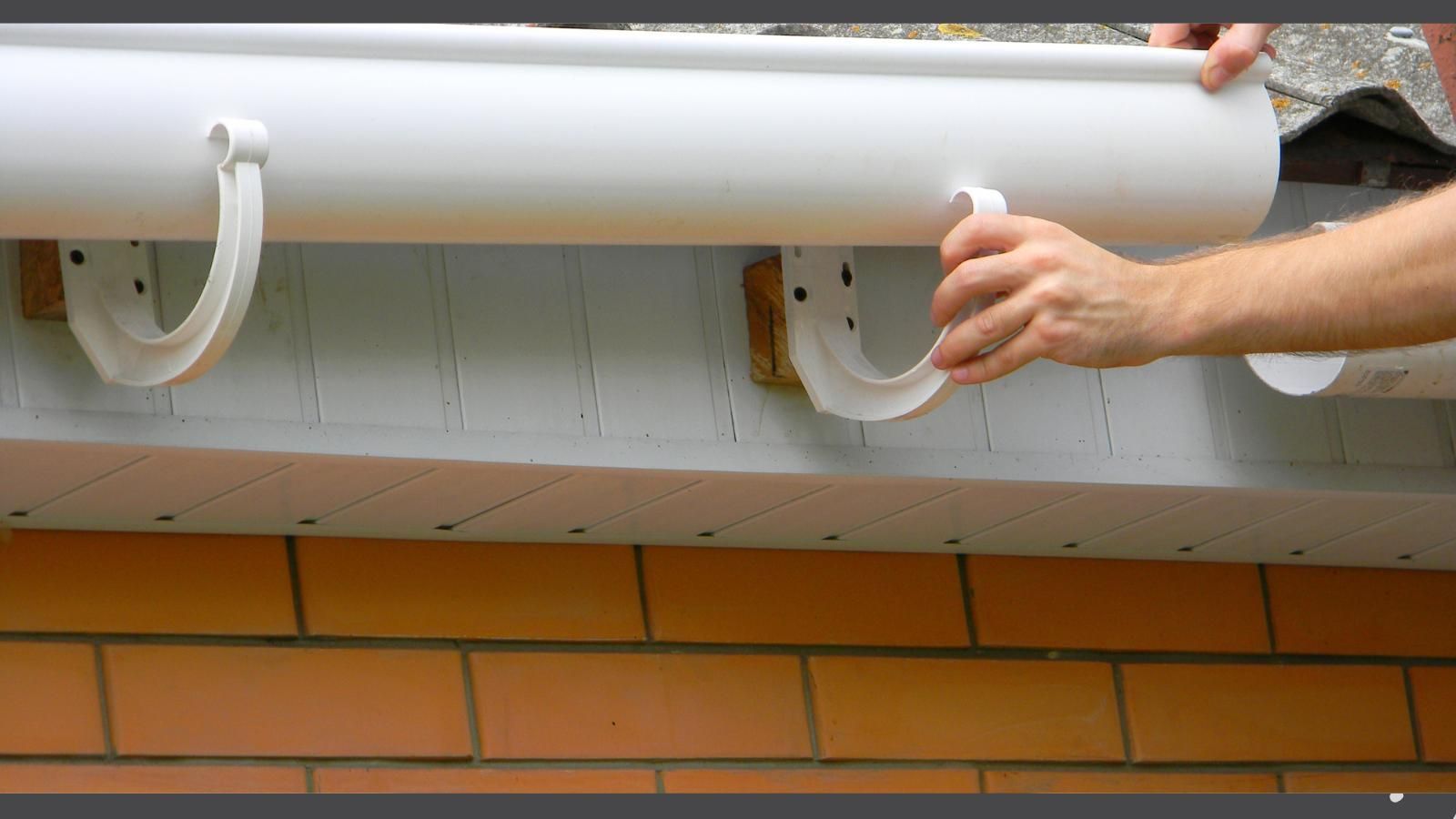 Hands installing a gutter