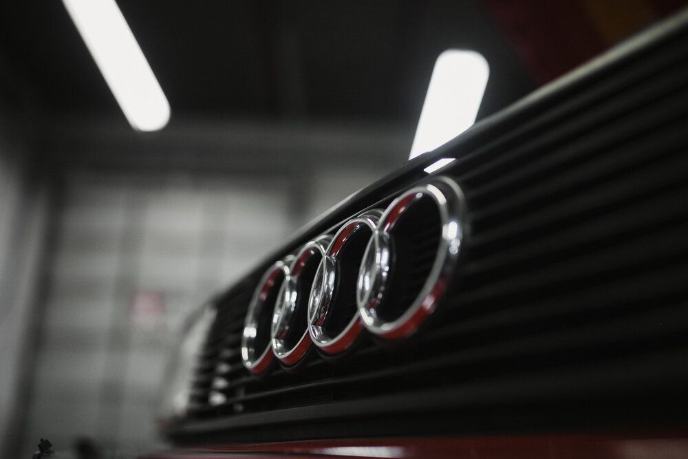 A close up of an audi logo on the front of a car.
