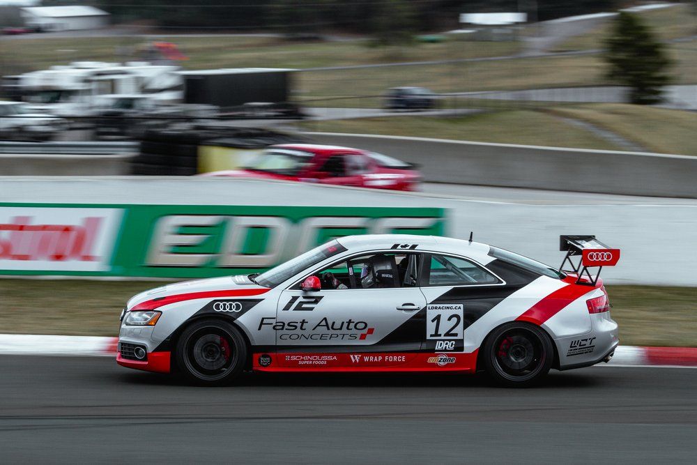 A race car with the number 12 on the side is driving on a track.