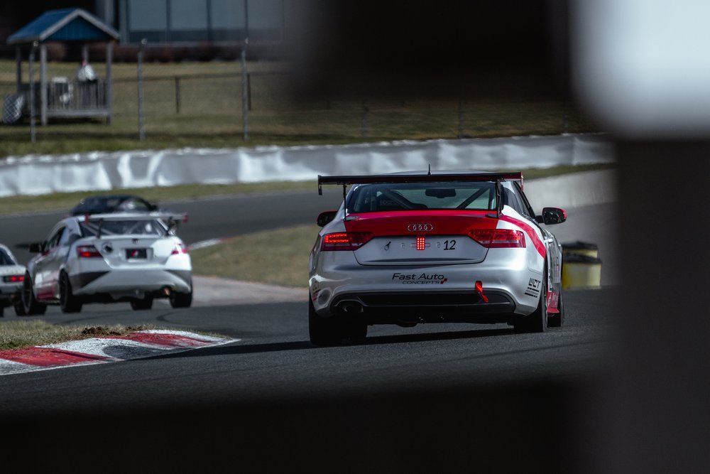 A group of cars are racing on a race track.