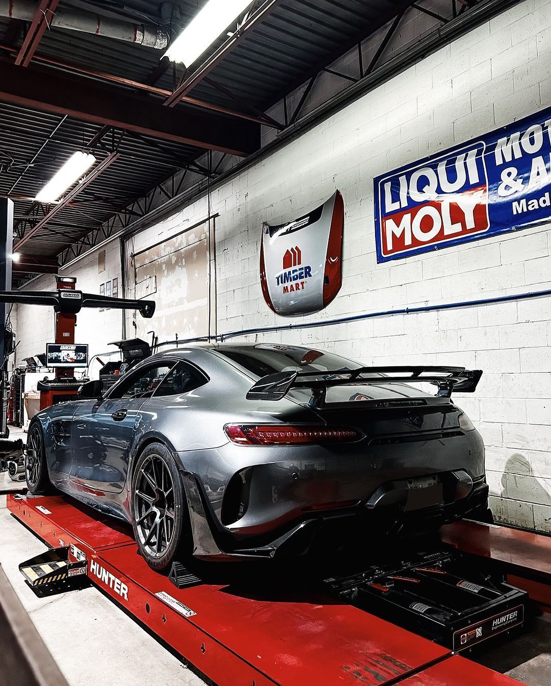 A car is sitting on a lift in a garage.