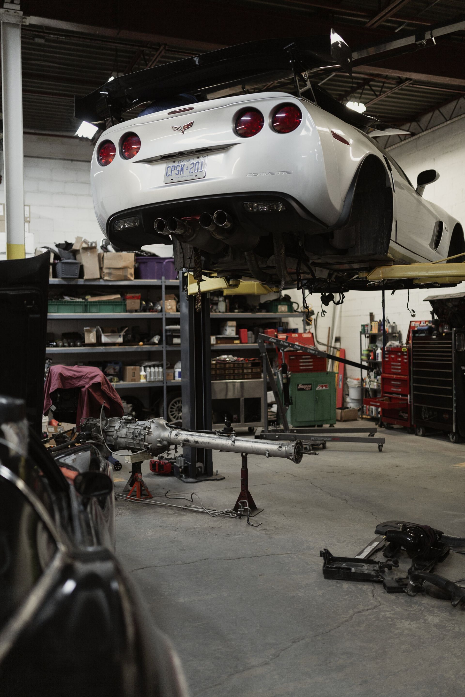 A car is sitting on a lift in a garage.