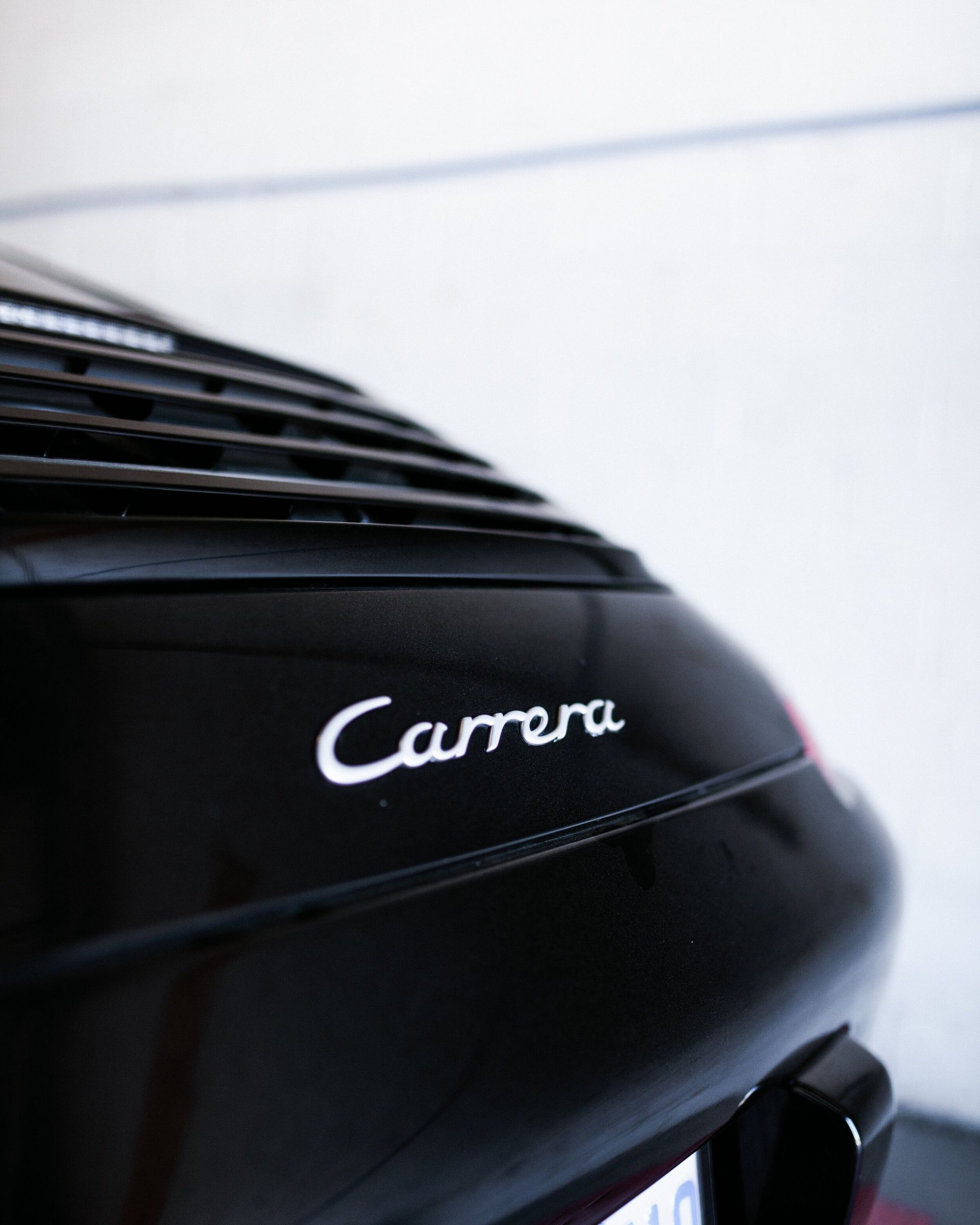 A black carrera car is parked in a garage