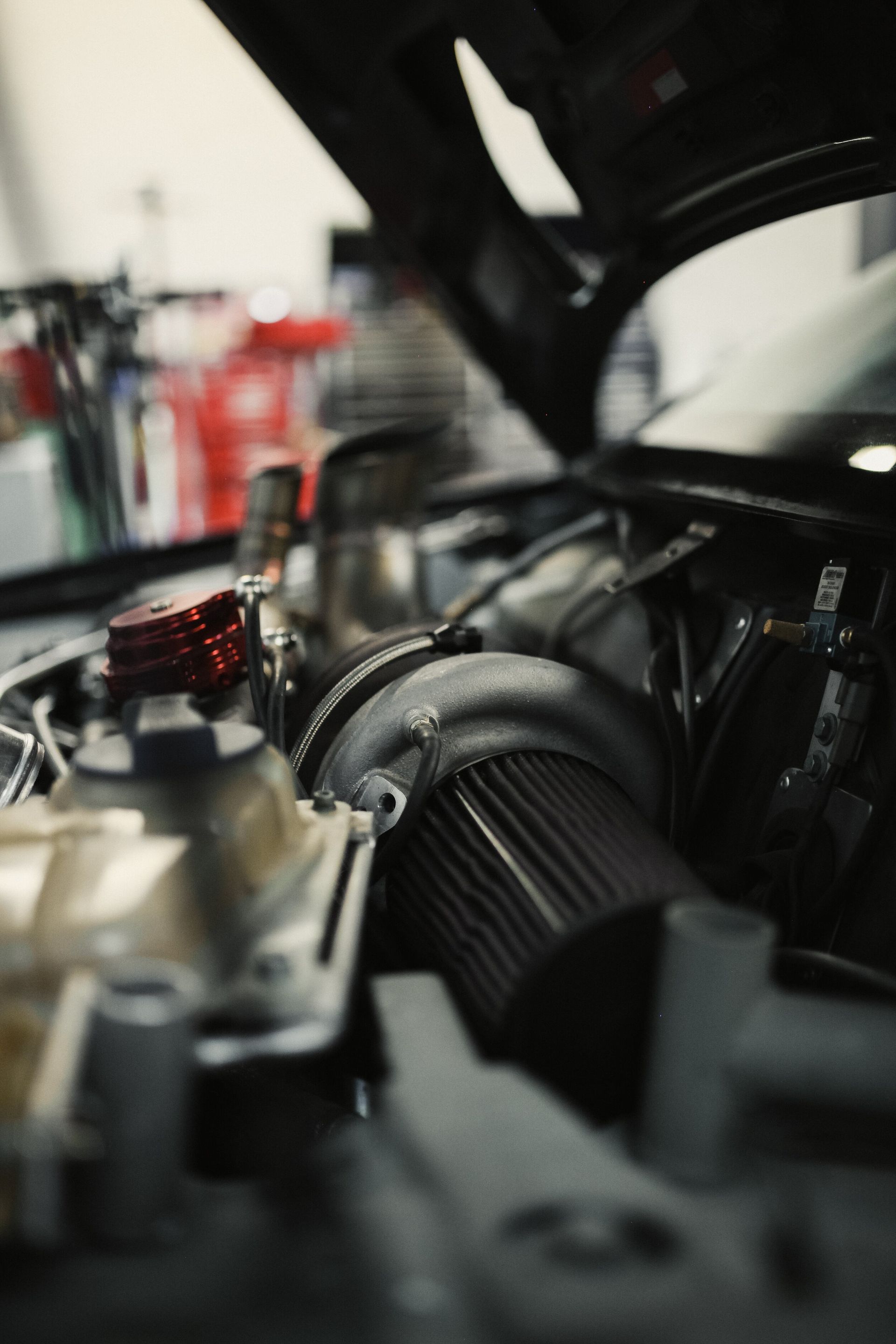 A close up of a car engine with the hood open.