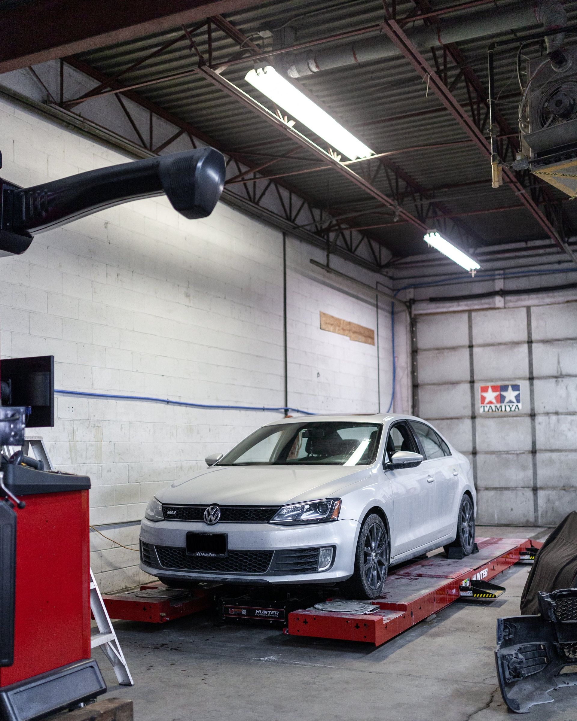 A white car is sitting on a ramp in a garage