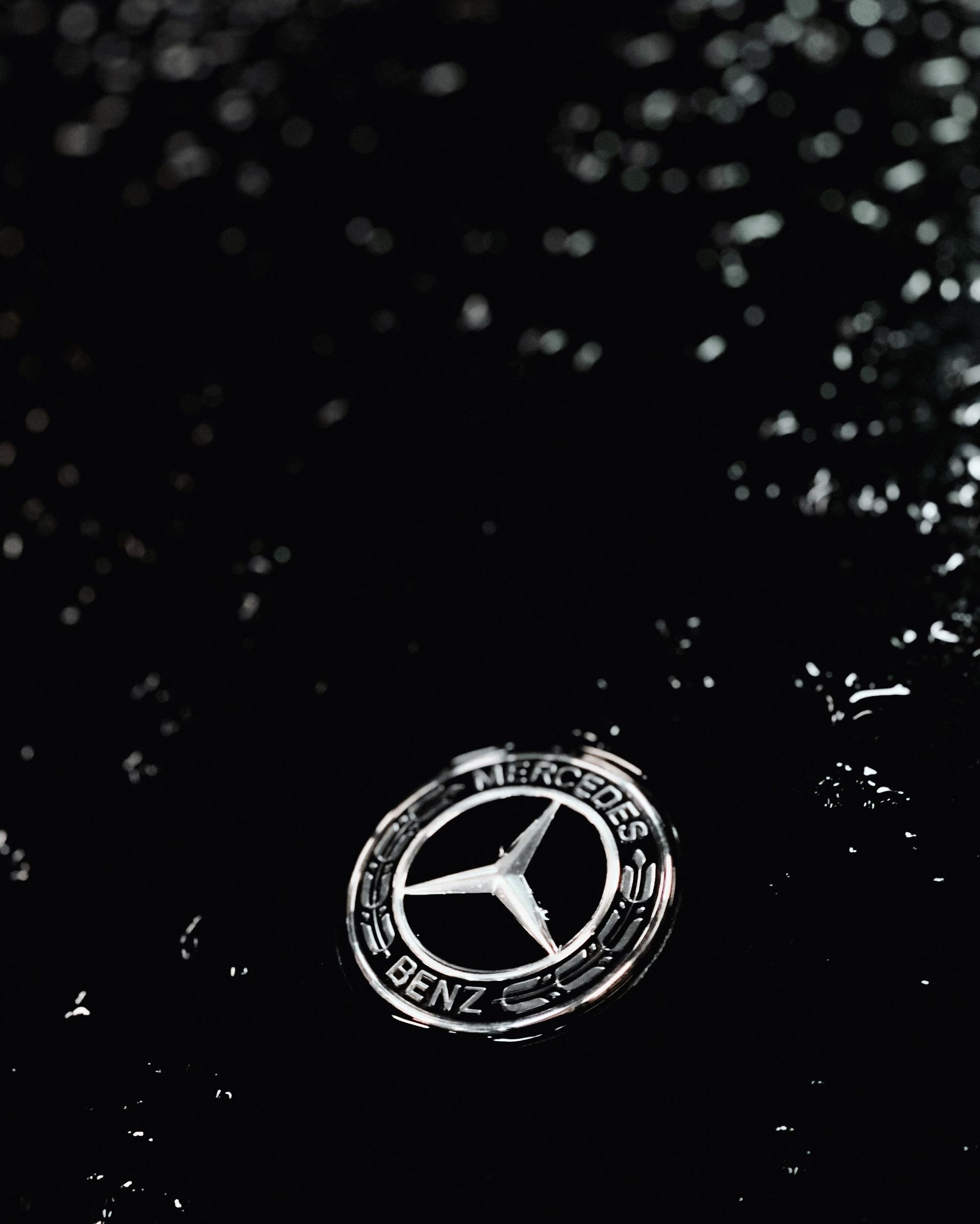 A close up of a mercedes logo on a black background