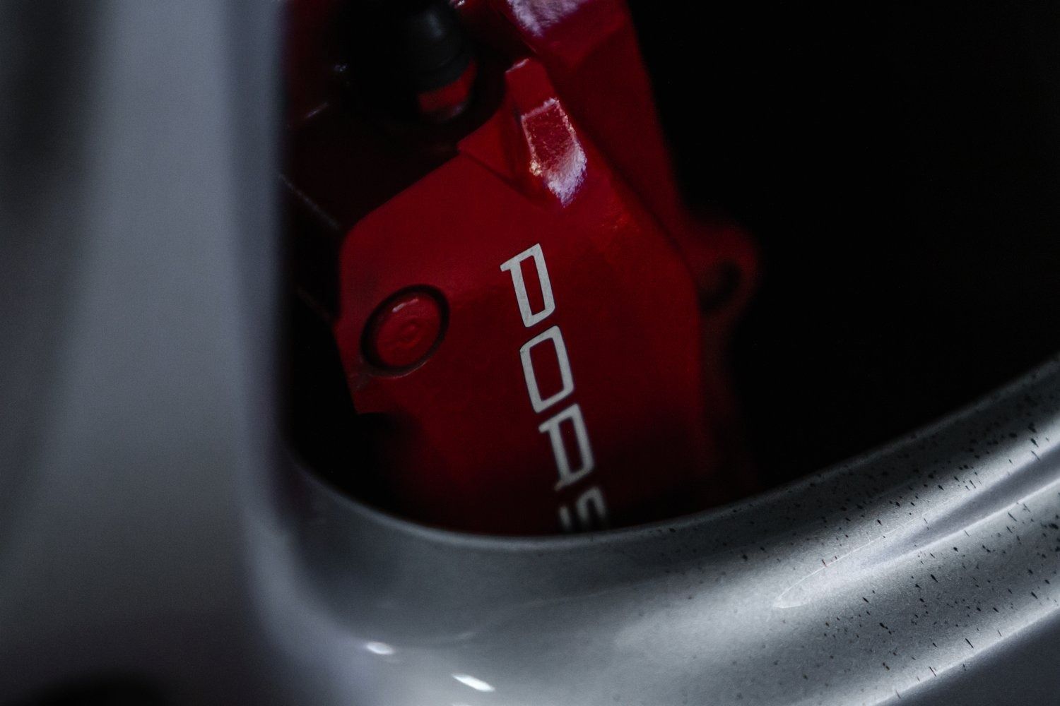 A close up of a red porsche brake caliper