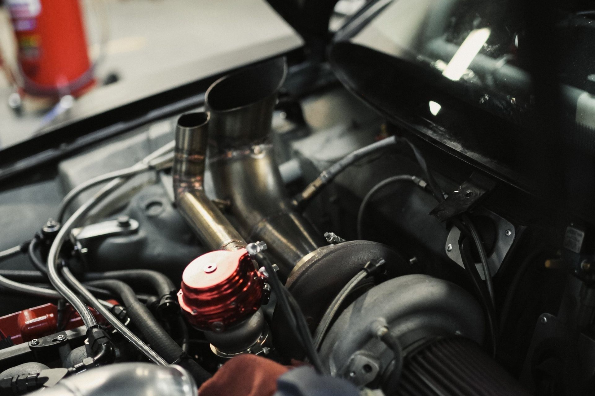 A close up of a car engine with the hood open