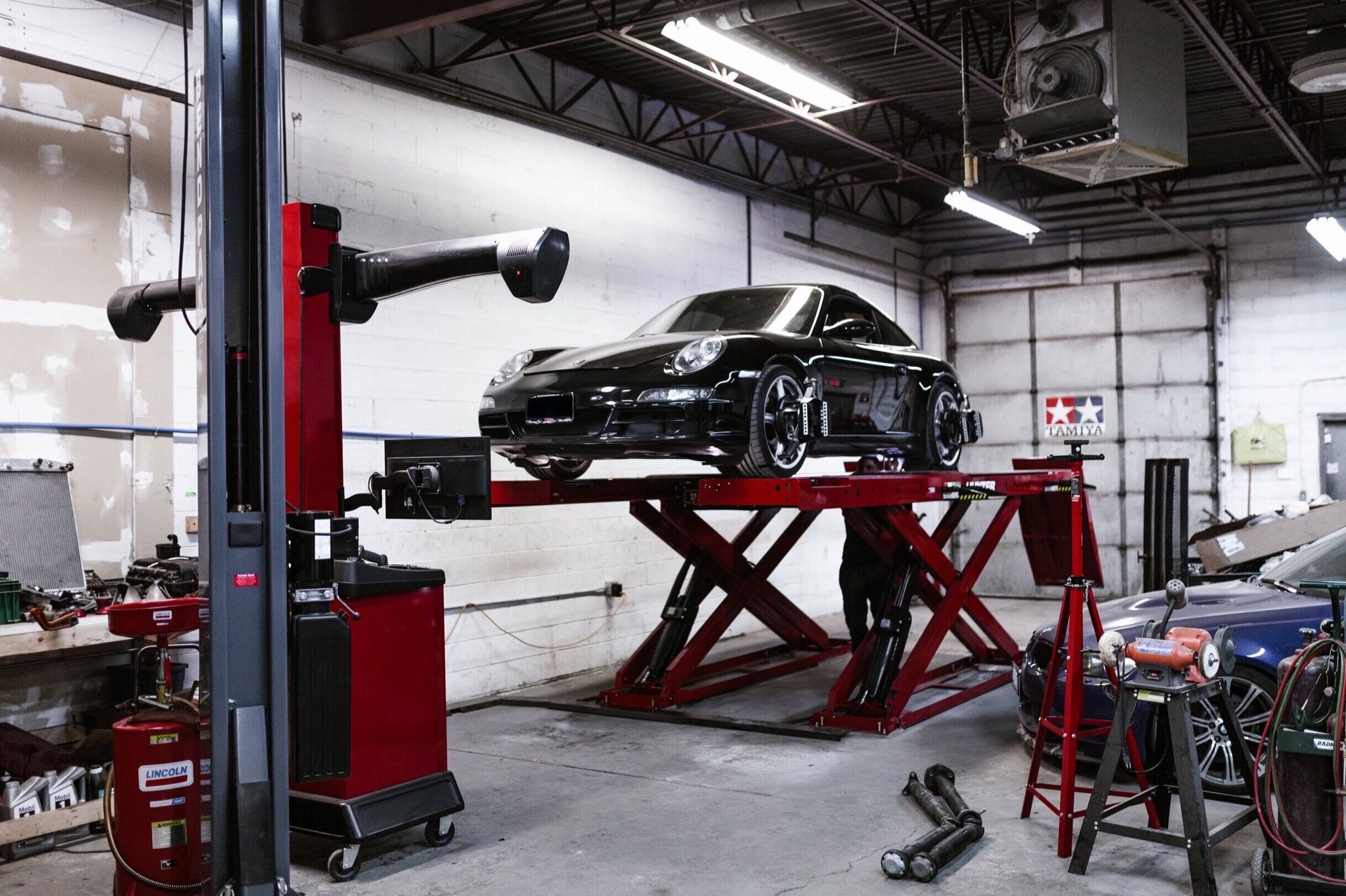 A car is sitting on a lift in a garage.