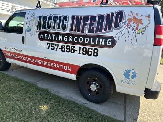 White Arctic Inferno van with logo and phone number parked on driveway.