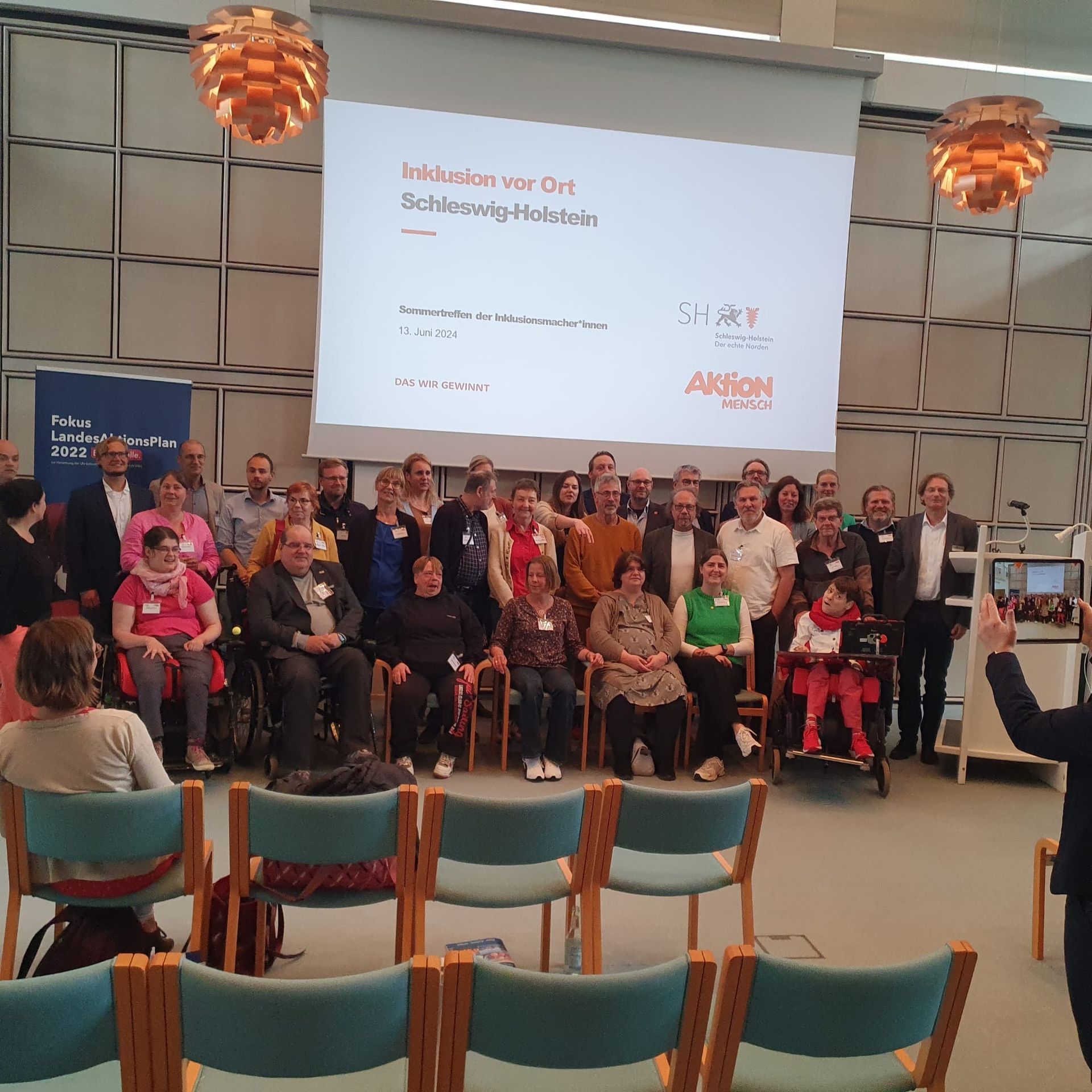 Ein Bild aller Anwesenden mit und ohne Behinderungen. Groß und Klein, alle schauen zusammen in die Kamera.