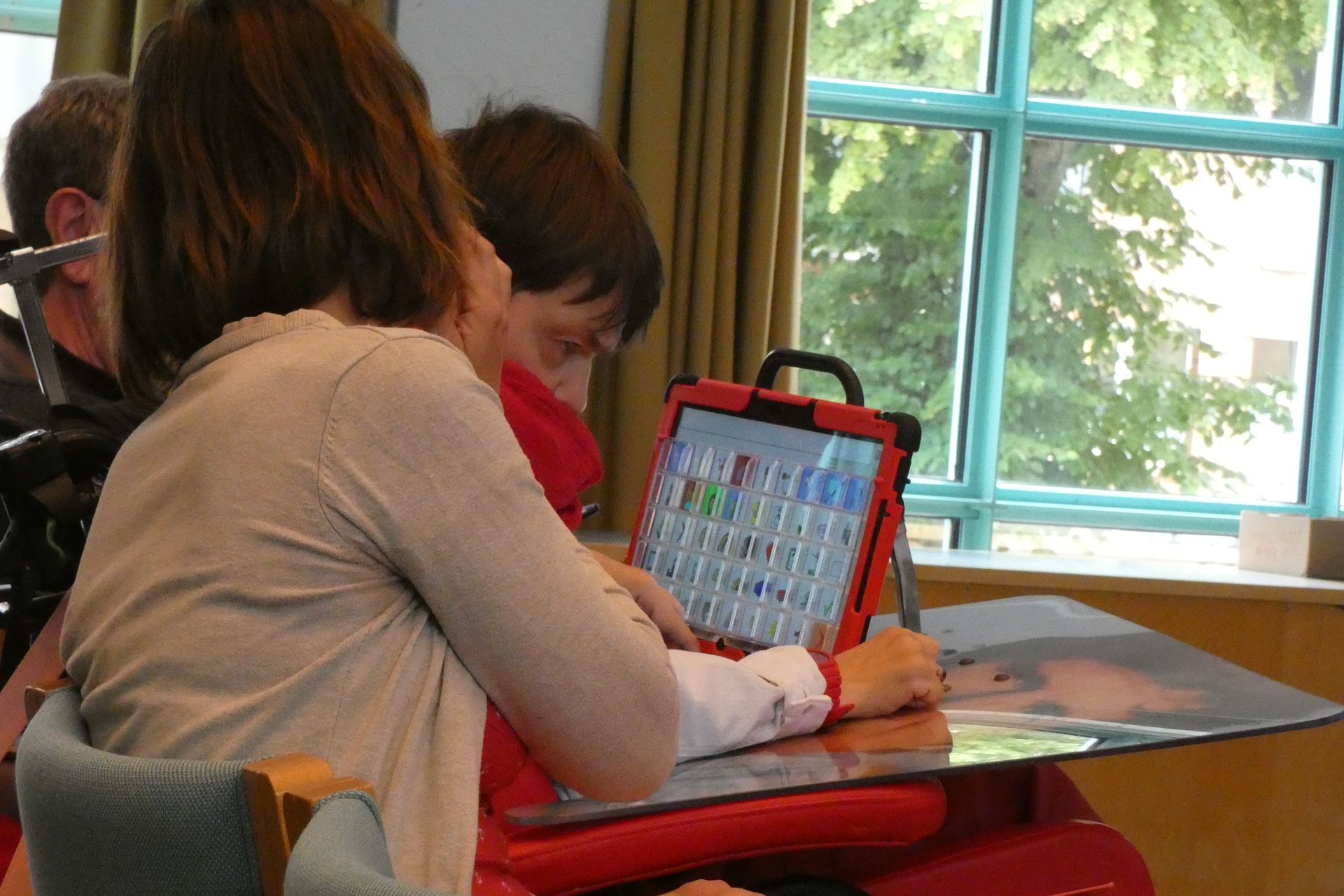 Eine junge Frau tippt auf einen Sprachcomputer.