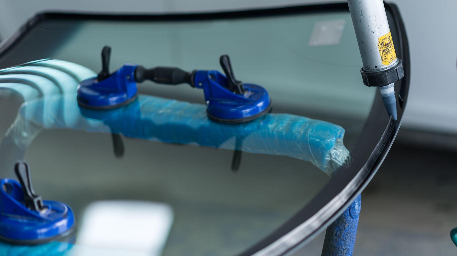 A close up of a windshield being installed on a car.