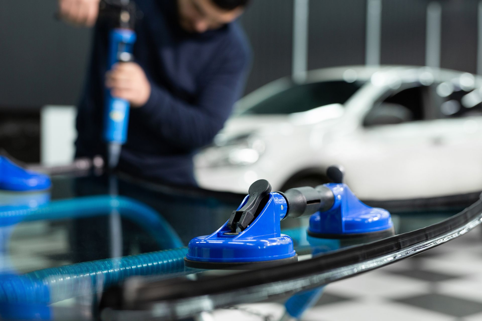 A man is installing a windshield on a car.