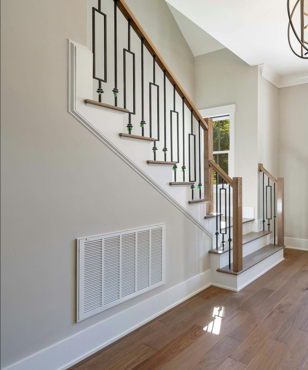 A hallway with a staircase and a window