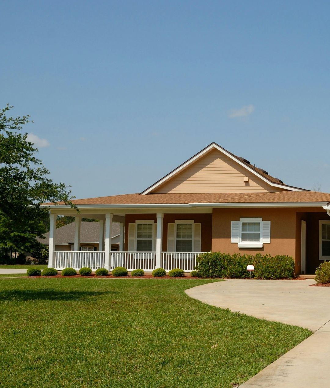 A house with a large porch and a concrete driveway