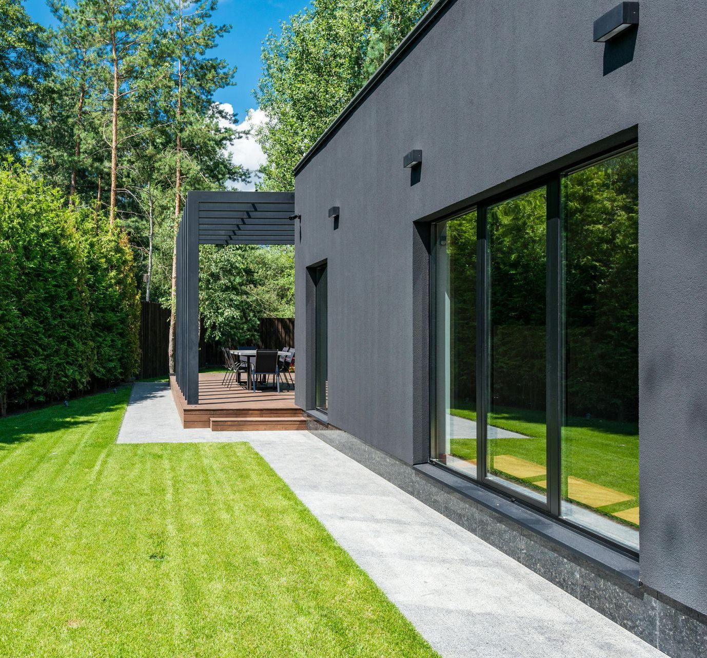 A black house with a large lawn in front of it